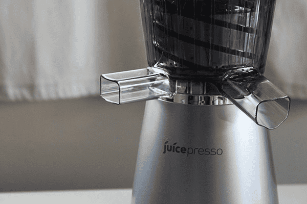 Close-up of the sleek, modern Coway Juicepresso juicer with its silver base and transparent upper chamber, designed for efficient and stylish juicing. The compact design and premium finish make it a perfect addition to any kitchen.
